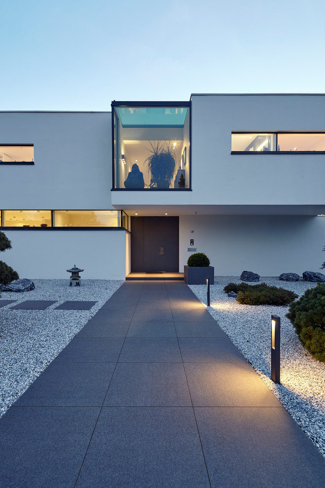 Mittelgroße Moderne Haustür mit weißer Wandfarbe, Betonboden, schwarzer Haustür und grauem Boden in Köln