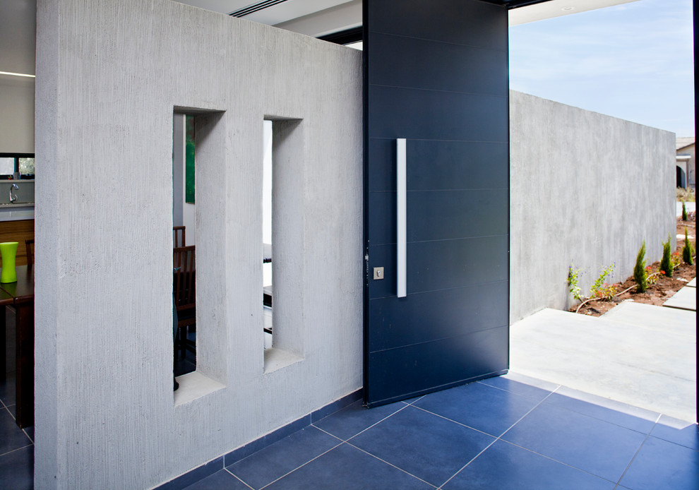 Idéer för en modern ingång och ytterdörr, med en svart dörr och blått golv