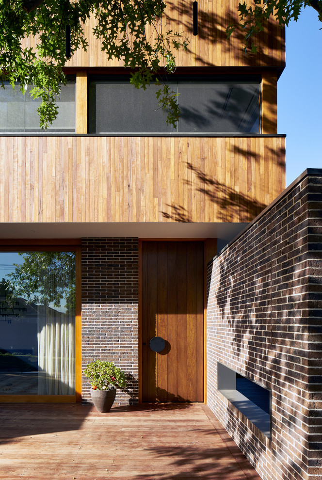 Moderne Haustür mit brauner Wandfarbe, dunklem Holzboden, Einzeltür, dunkler Holzhaustür und braunem Boden in Melbourne