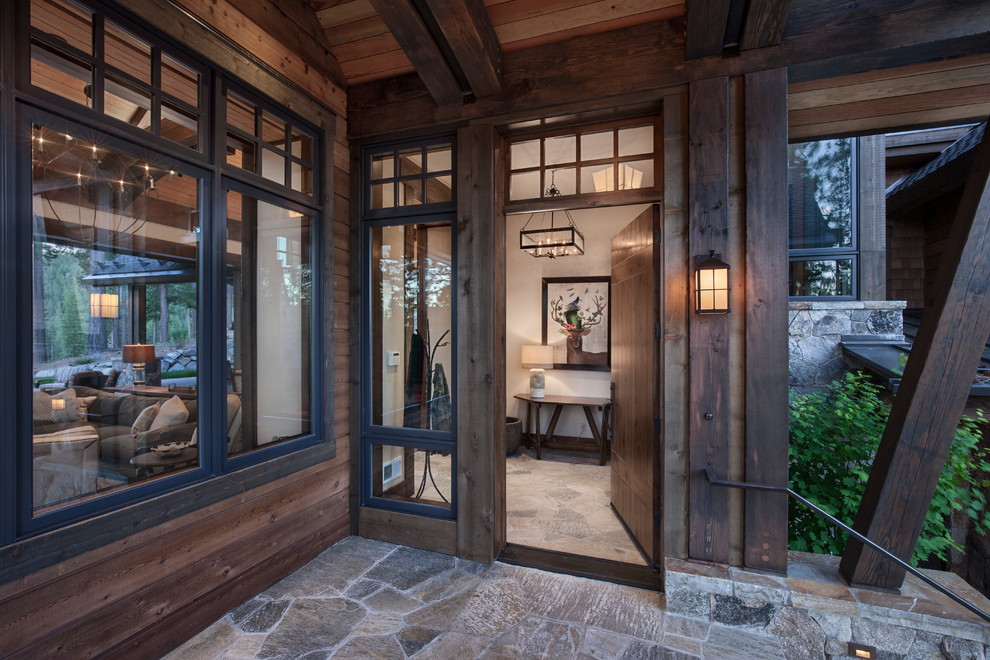 Aménagement d'une porte d'entrée craftsman de taille moyenne avec un sol en ardoise, une porte simple et une porte en bois foncé.