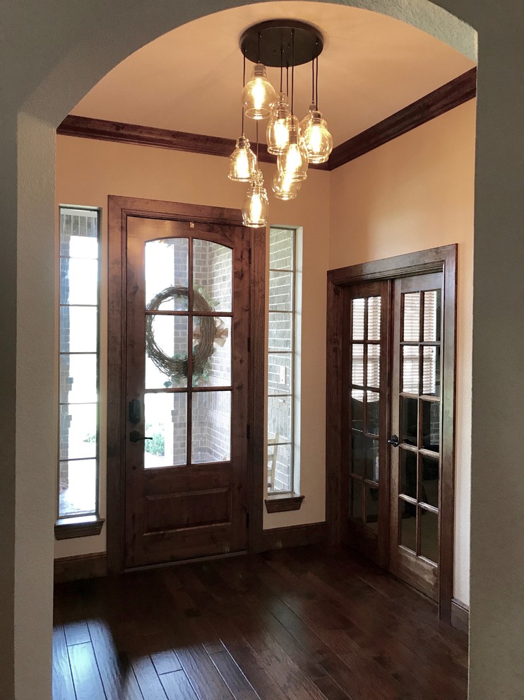 Пример оригинального дизайна: входная дверь среднего размера в стиле неоклассика (современная классика) с одностворчатой входной дверью, коричневой входной дверью, бежевыми стенами, темным паркетным полом и коричневым полом