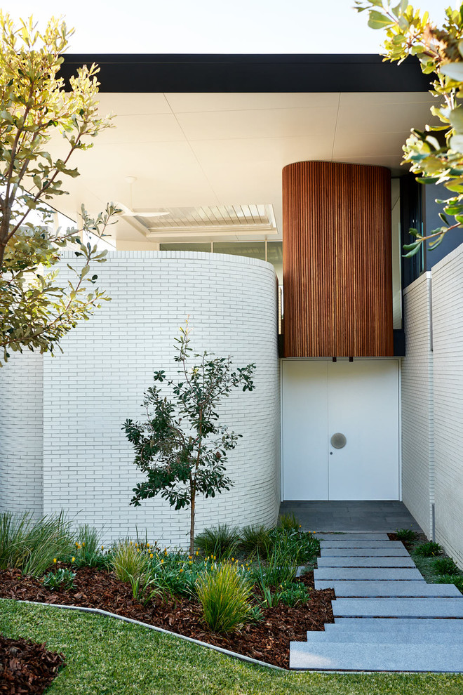 Moderner Eingang mit weißer Wandfarbe, Betonboden, Einzeltür, weißer Haustür und grauem Boden in Sydney