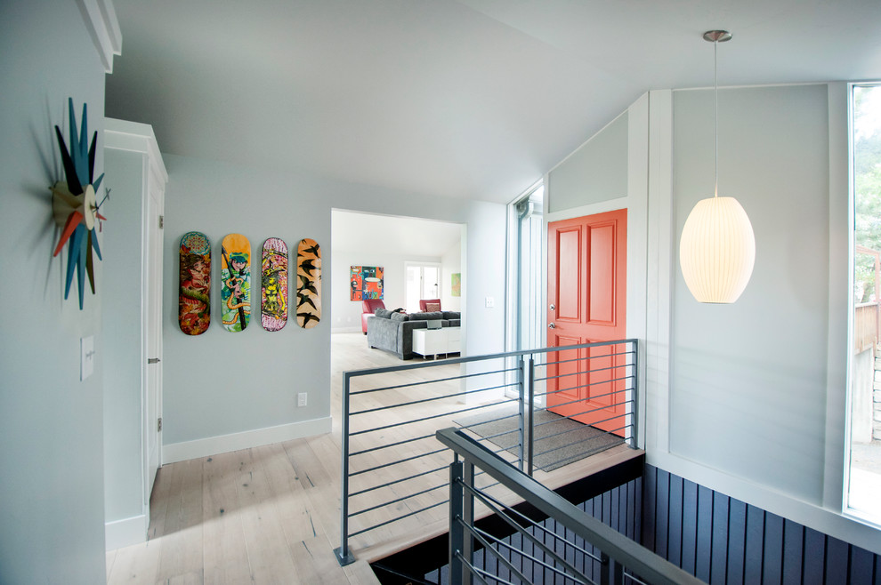 Inspiration pour une porte d'entrée design avec un mur gris, parquet clair, une porte simple et une porte orange.