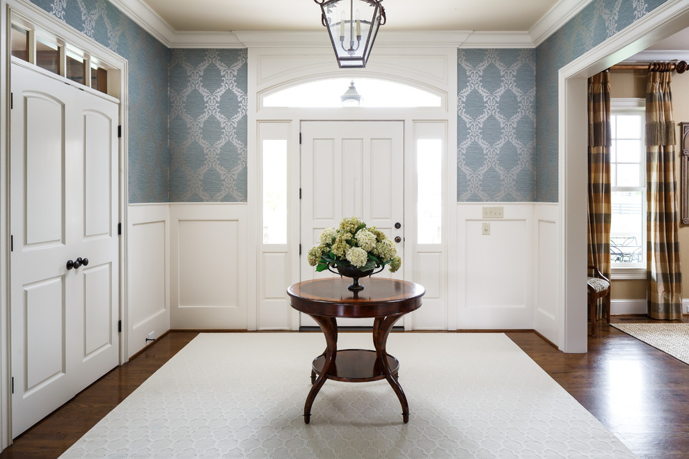 Idéer för vintage entréer, med blå väggar, mellanmörkt trägolv, en enkeldörr, en vit dörr och brunt golv