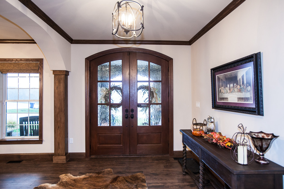 Imagen de puerta principal rústica grande con paredes beige, suelo de madera oscura, puerta doble y puerta de madera oscura