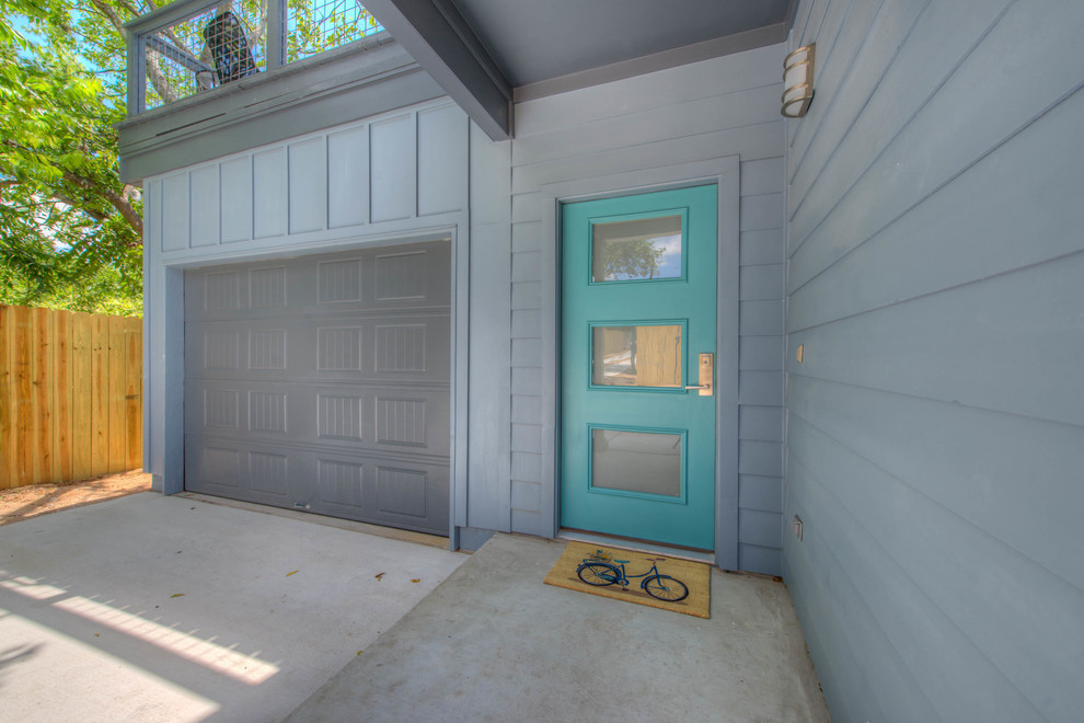 Design ideas for a medium sized modern front door in Austin with blue walls, concrete flooring, a single front door, a glass front door and grey floors.