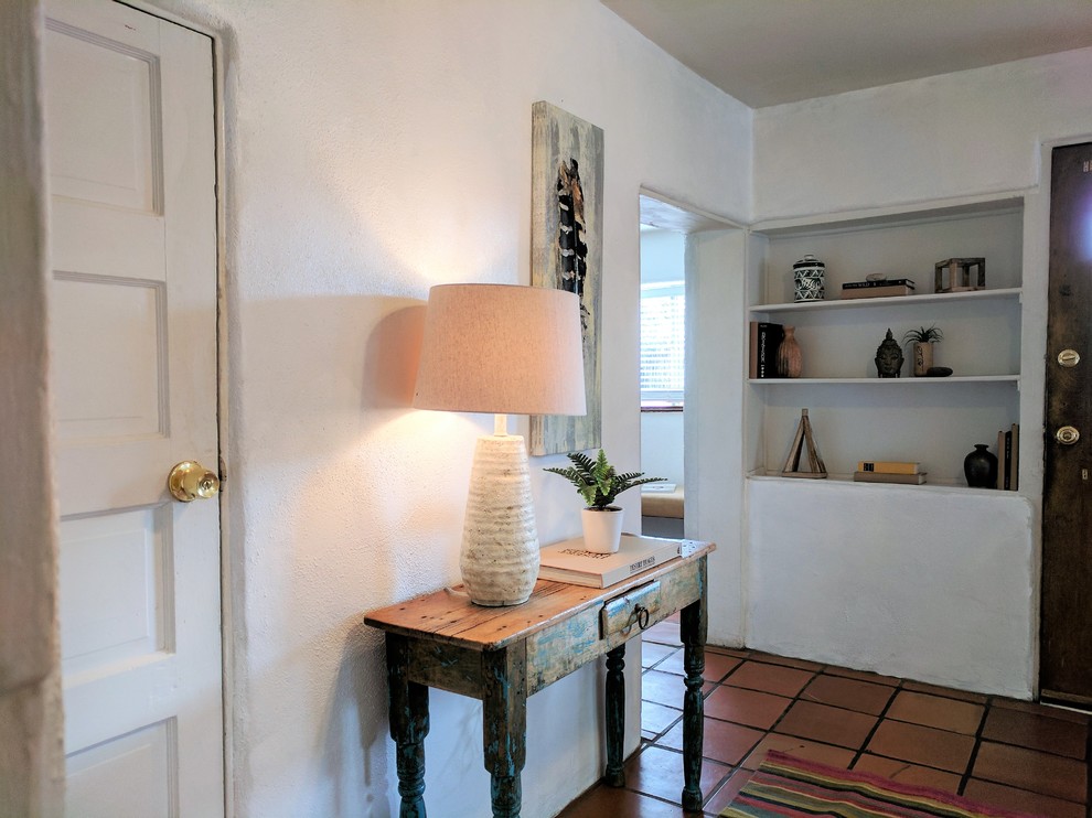 На фото: маленькое фойе в стиле фьюжн с белыми стенами, полом из терракотовой плитки, одностворчатой входной дверью, коричневой входной дверью и оранжевым полом для на участке и в саду с