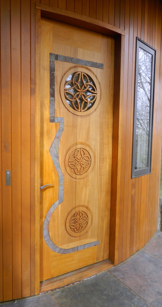Bild på en stor funkis ingång och ytterdörr, med bruna väggar, skiffergolv, en enkeldörr och mellanmörk trädörr