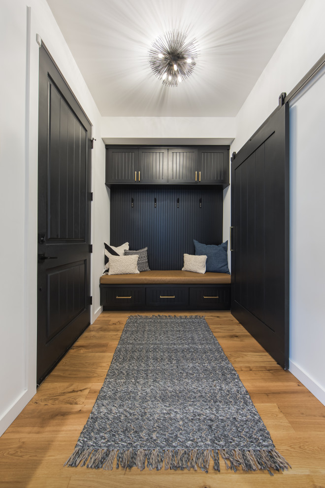 Diseño de vestíbulo posterior tradicional renovado de tamaño medio con paredes blancas, suelo de madera en tonos medios, puerta simple, puerta negra y suelo beige