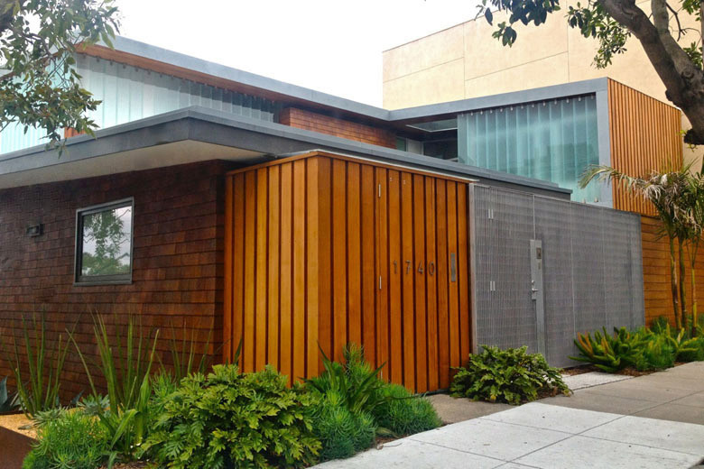 Modelo de entrada moderna con suelo de terrazo, puerta simple y puerta de madera en tonos medios