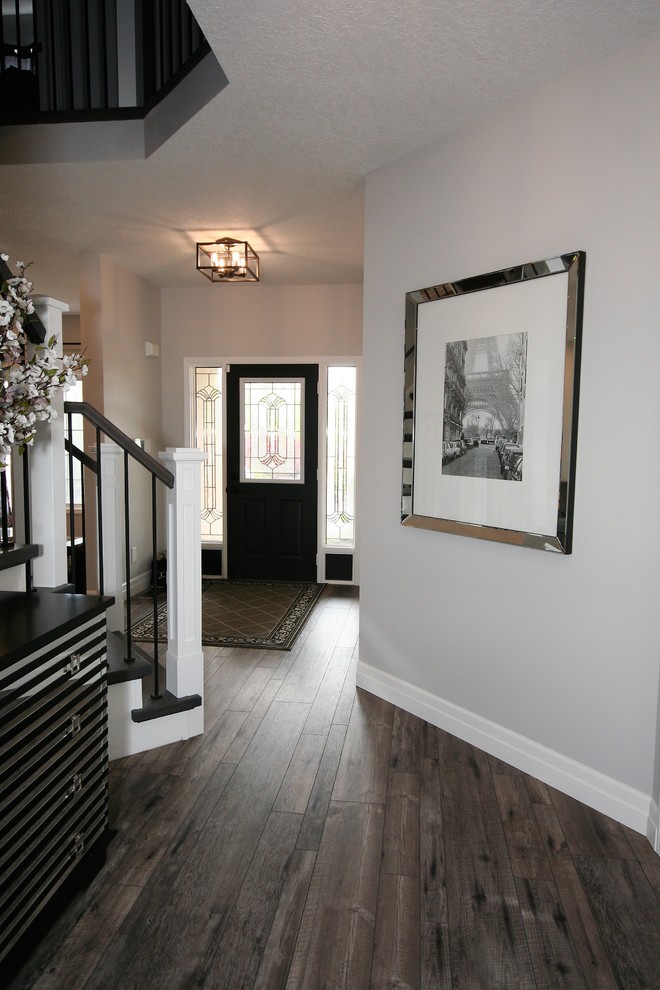 Ejemplo de entrada actual con paredes grises, suelo vinílico, puerta simple y puerta negra