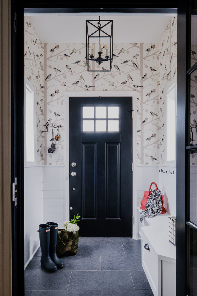 ニューヨークにあるお手頃価格の小さなトランジショナルスタイルのおしゃれな玄関ロビー (磁器タイルの床、黒いドア、グレーの床、壁紙) の写真