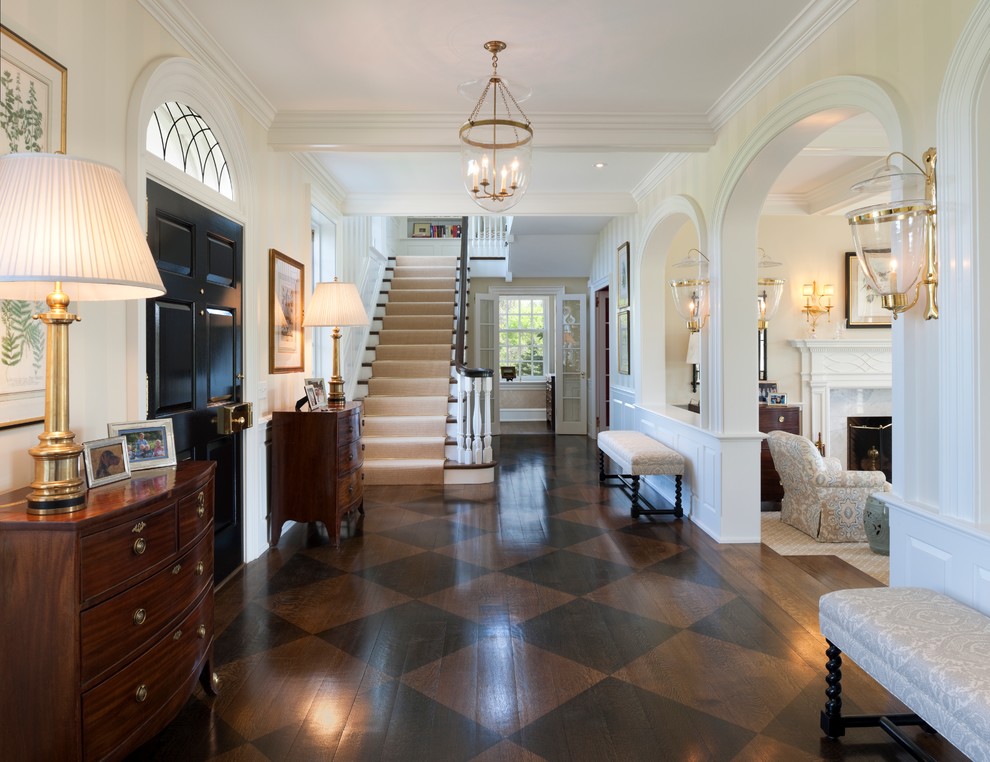 Klassisches Foyer mit beiger Wandfarbe, gebeiztem Holzboden, Einzeltür, schwarzer Haustür und braunem Boden in Philadelphia