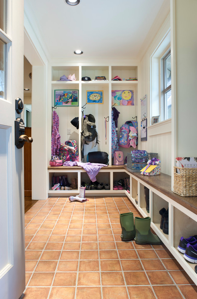 This is an example of a classic boot room in Other with white walls and a white front door.