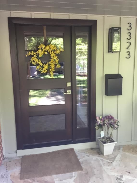 Immagine di una porta d'ingresso minimalista di medie dimensioni con una porta singola e una porta in vetro