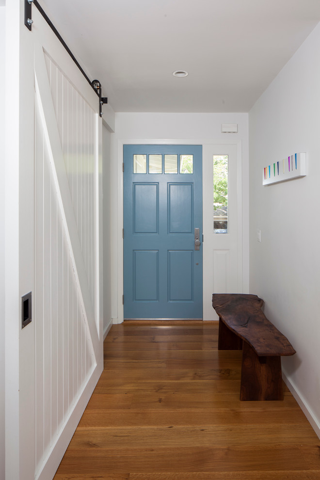 Esempio di un ingresso o corridoio minimal con una porta blu