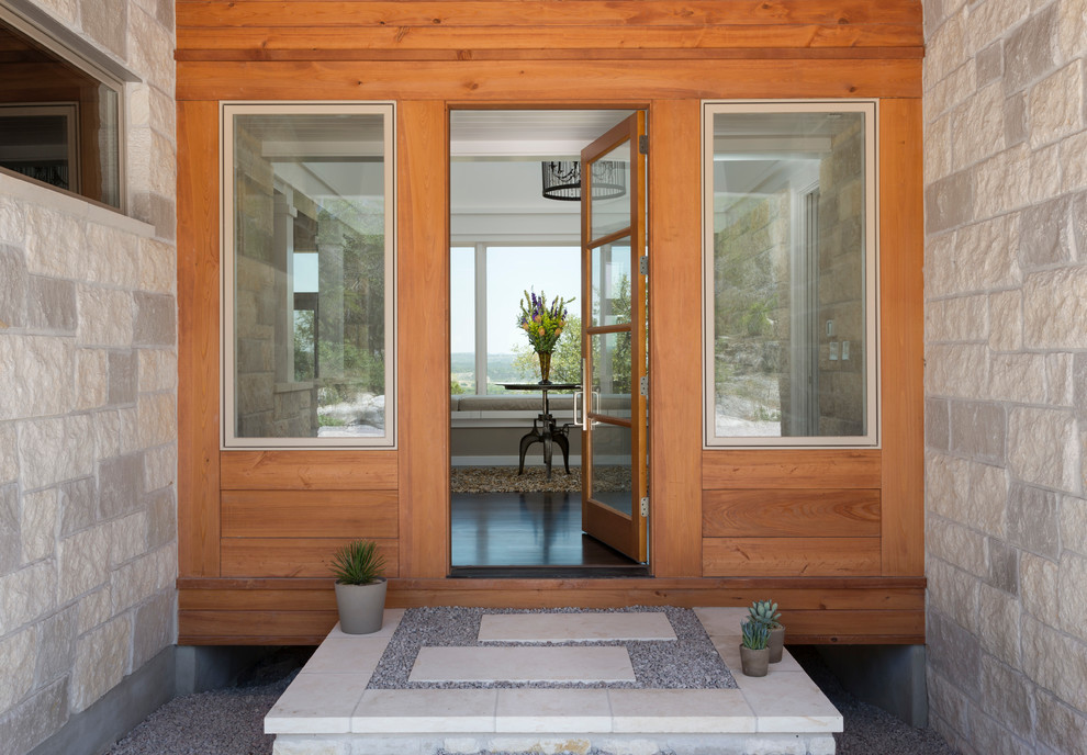Rustic front door in Austin with grey walls, concrete flooring, a single front door and a medium wood front door.