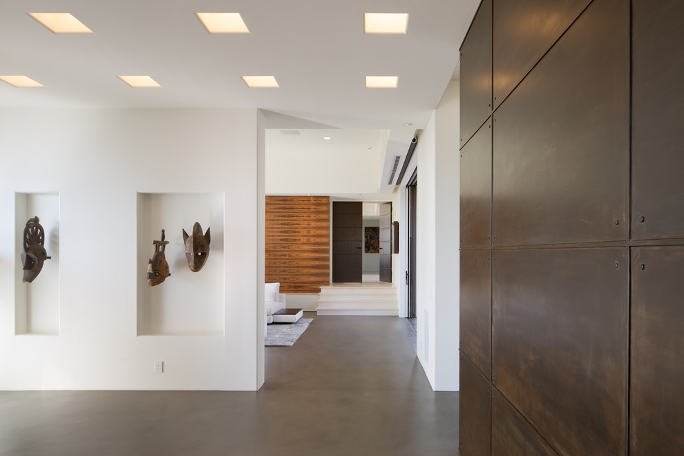 Inspiration for a large contemporary concrete floor and gray floor entryway remodel in San Diego with white walls and a brown front door