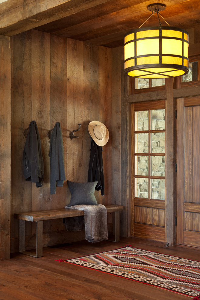 Foto de entrada rural con paredes marrones, puerta simple, puerta de madera en tonos medios y suelo de madera oscura