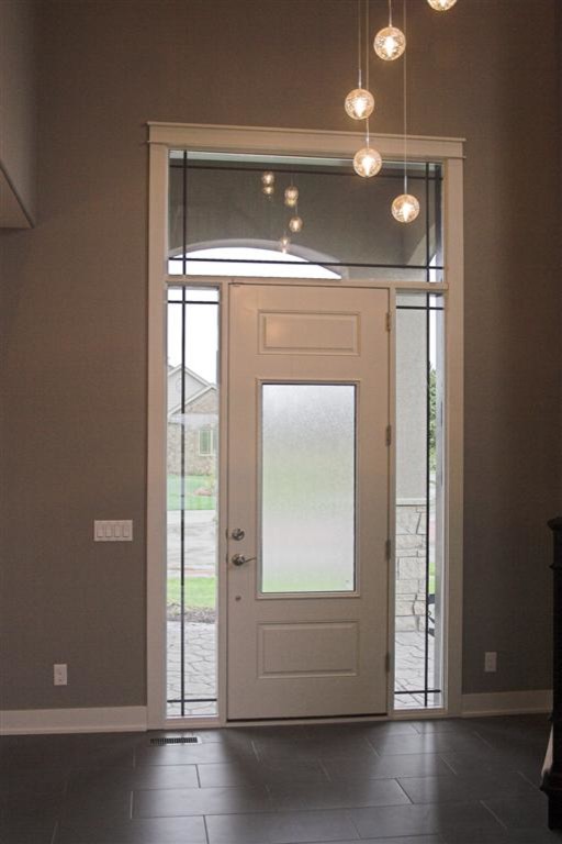 Cette image montre un hall d'entrée traditionnel avec une porte simple, un mur gris, un sol en carrelage de céramique et une porte blanche.