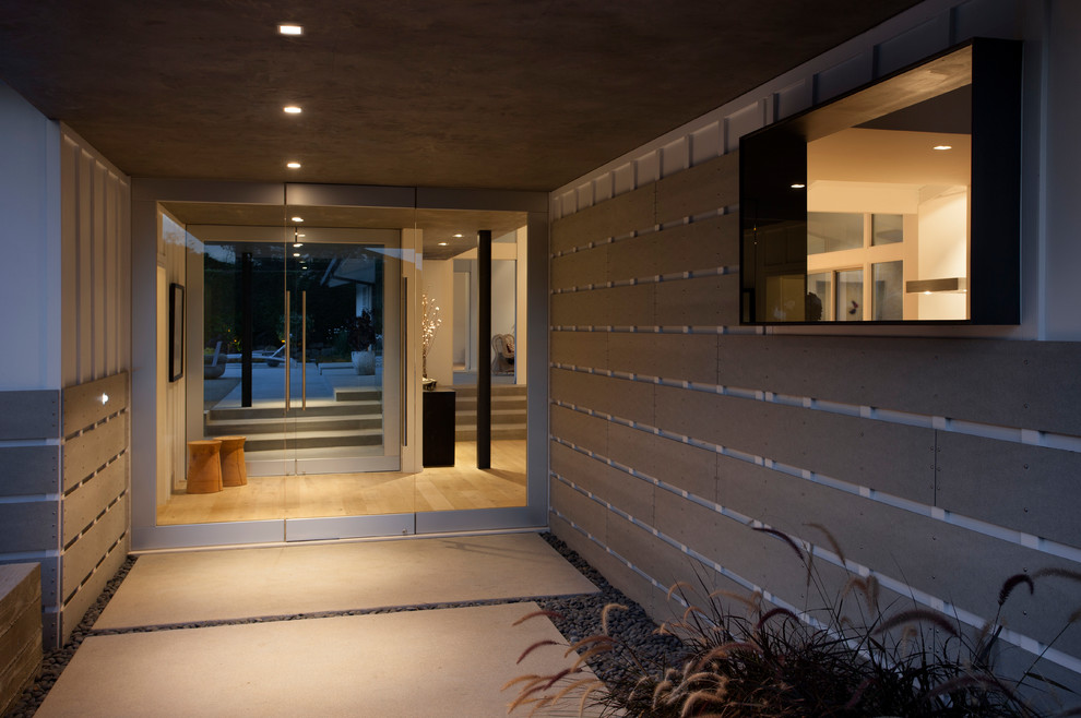 Foto di una porta d'ingresso design di medie dimensioni con pavimento in cemento, una porta a due ante e una porta in vetro