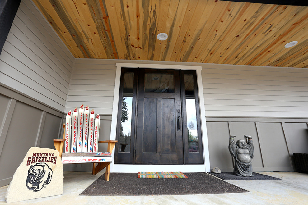 Réalisation d'une grande porte d'entrée tradition avec une porte simple, une porte en bois foncé, un mur gris, un sol en contreplaqué et un sol beige.