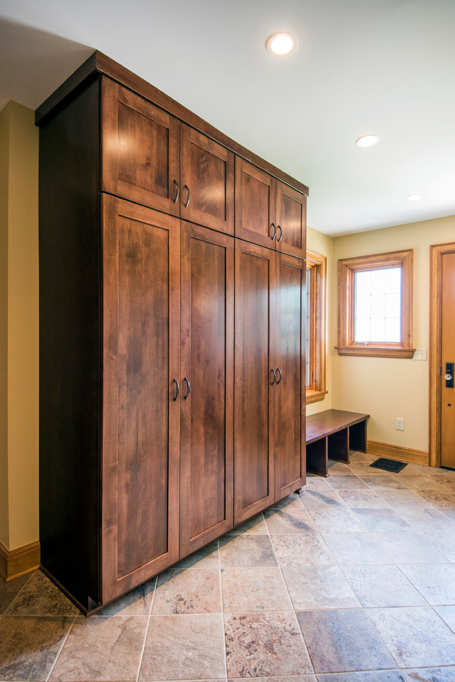 This is an example of a medium sized traditional boot room in Columbus with beige walls, ceramic flooring, a single front door and a medium wood front door.