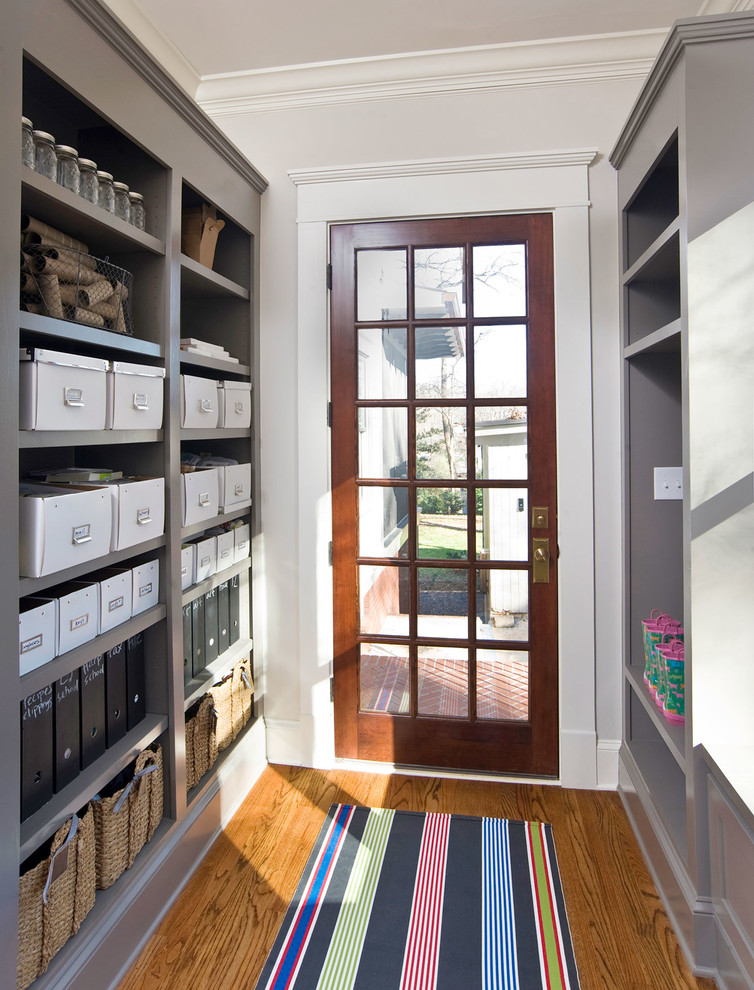 Elegant medium tone wood floor entryway photo in Atlanta with gray walls and a glass front door