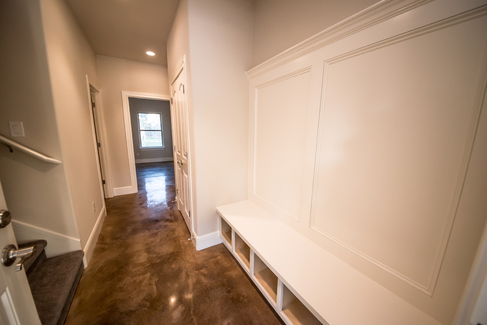 Cette image montre une entrée craftsman de taille moyenne avec sol en béton ciré, un vestiaire et un mur beige.
