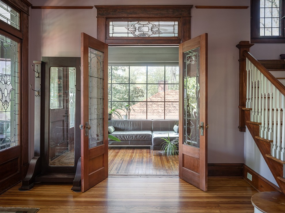 Entryway - large craftsman light wood floor and brown floor entryway idea in Atlanta with white walls and a medium wood front door