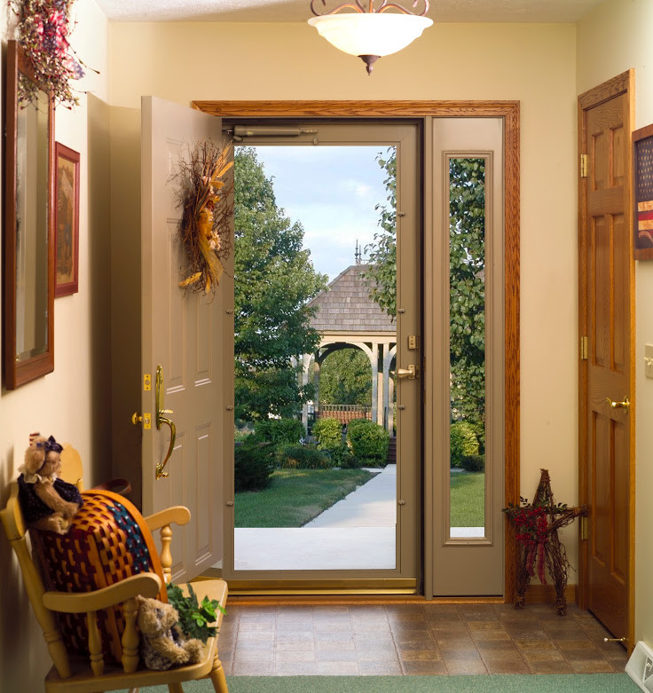 Пример оригинального дизайна: входная дверь среднего размера: освещение в классическом стиле с бежевыми стенами, одностворчатой входной дверью, коричневой входной дверью и коричневым полом