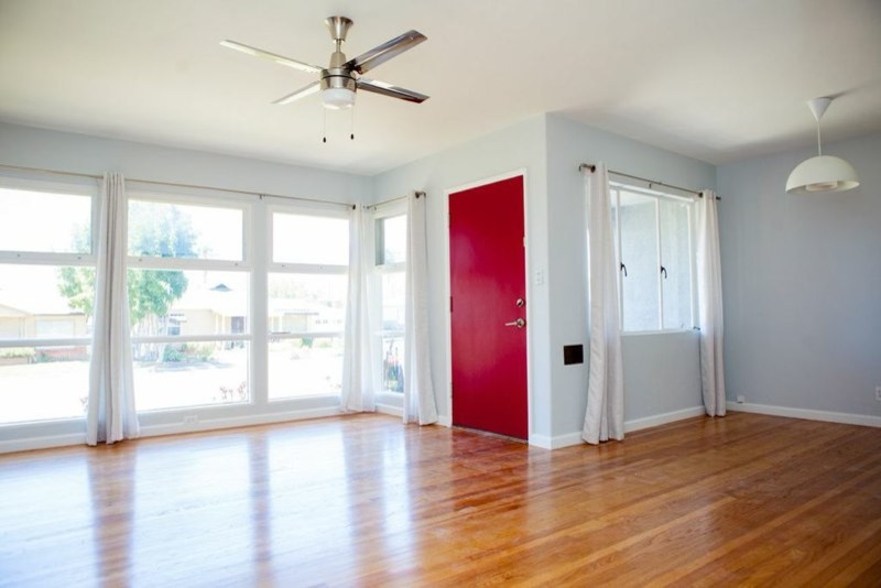 他の地域にある広いトランジショナルスタイルのおしゃれな玄関ドア (グレーの壁、淡色無垢フローリング、赤いドア、ベージュの床) の写真