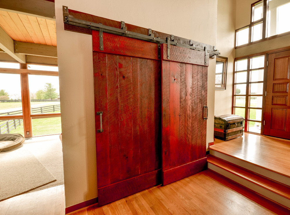Foto på en liten funkis foajé, med beige väggar, ljust trägolv, en dubbeldörr, en röd dörr och beiget golv