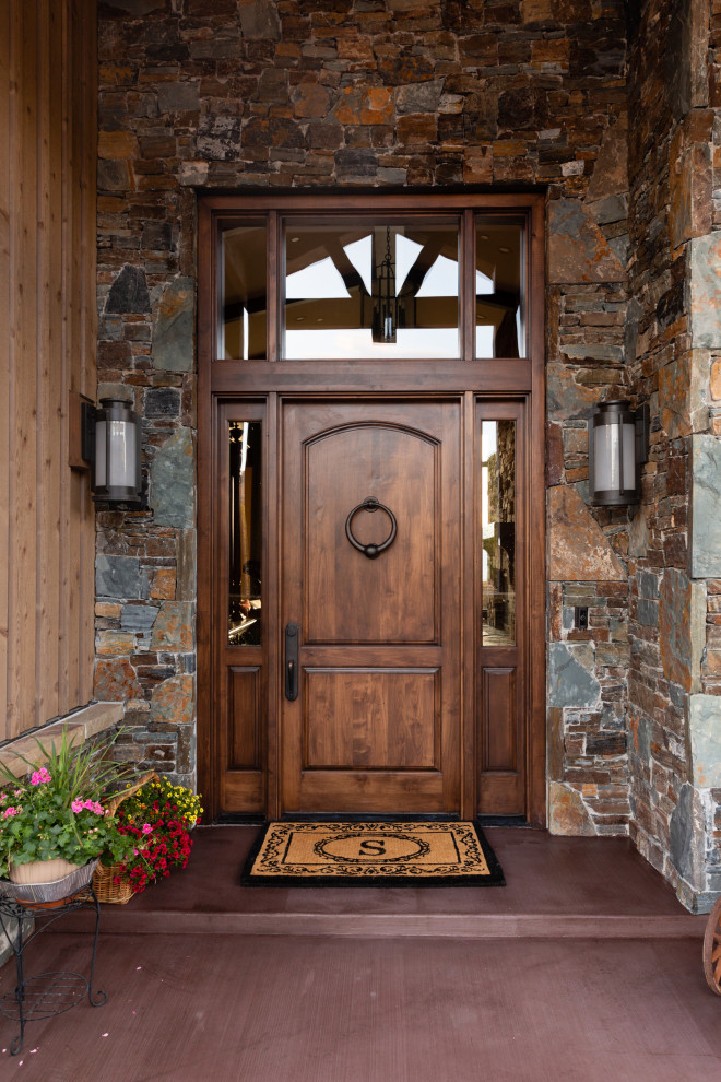 На фото: входная дверь в стиле рустика с одностворчатой входной дверью и входной дверью из темного дерева