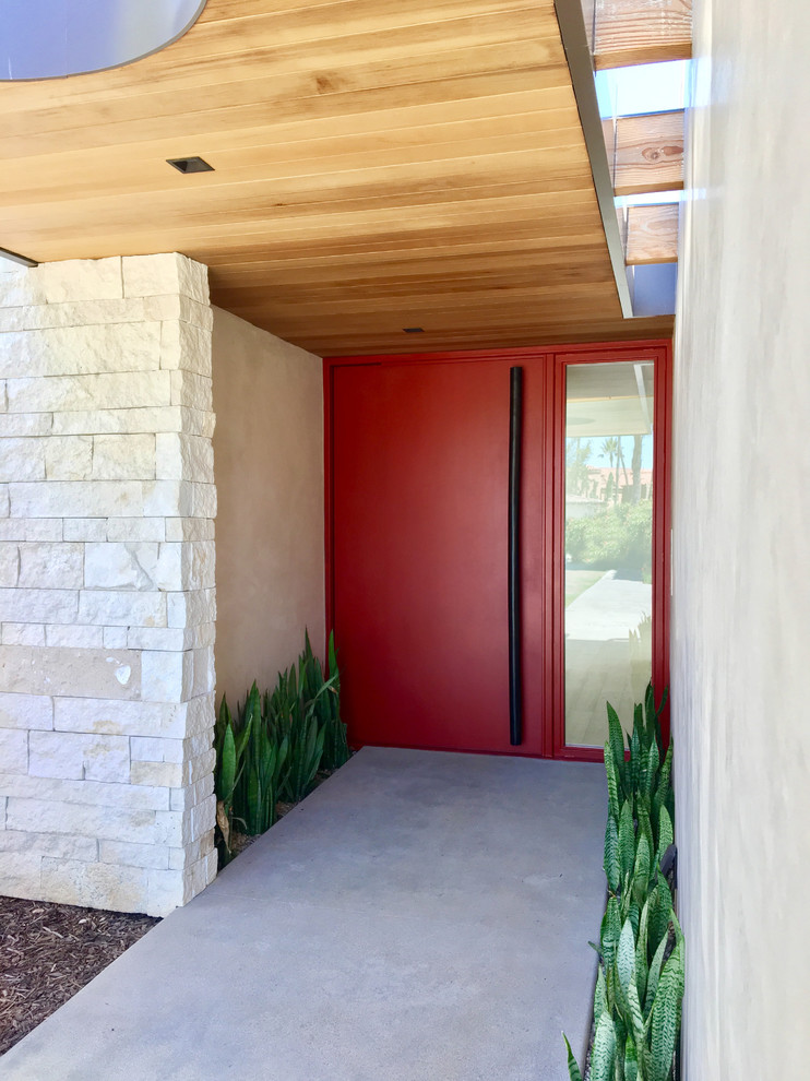 Exempel på en stor modern ingång och ytterdörr, med beige väggar, betonggolv, en pivotdörr, en röd dörr och grått golv