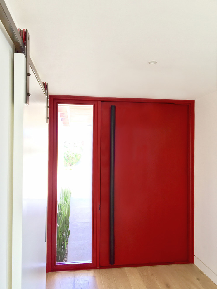 Exemple d'une grande porte d'entrée moderne avec un mur blanc, parquet clair, une porte pivot, une porte rouge et un sol beige.
