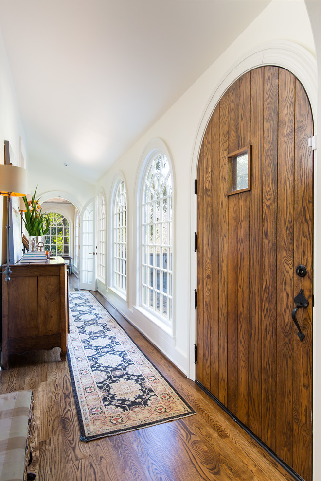 Foto de puerta principal campestre de tamaño medio con paredes blancas, suelo de madera oscura, puerta simple, puerta de madera oscura y suelo marrón
