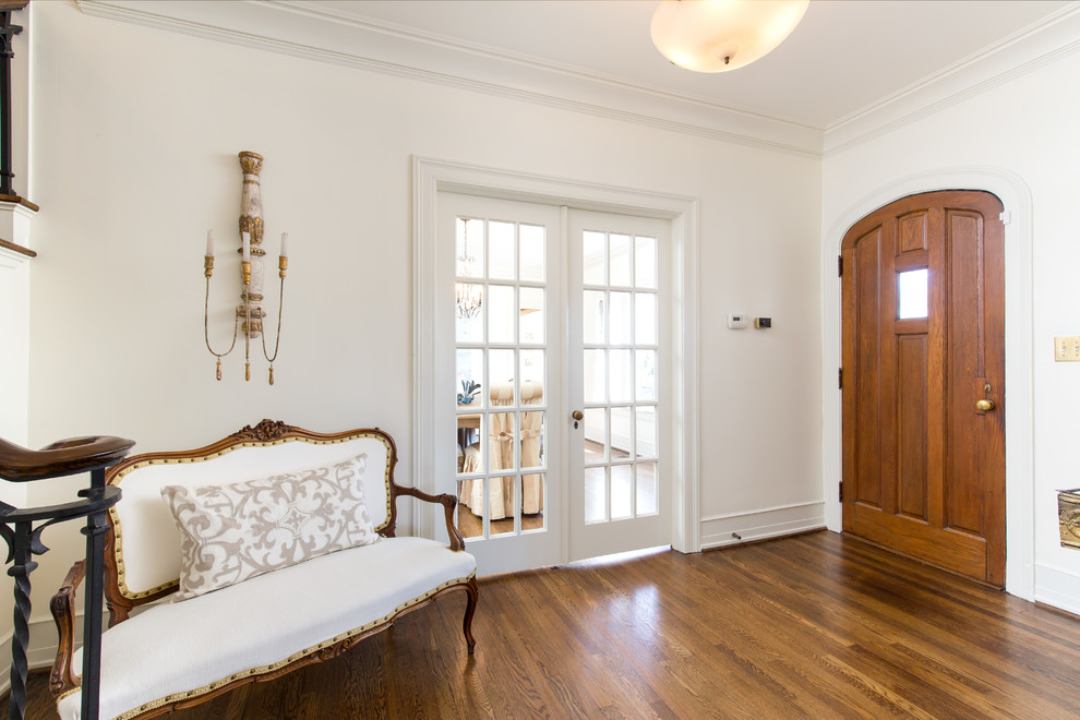 Imagen de distribuidor campestre de tamaño medio con paredes blancas, suelo de madera clara, puerta simple, puerta de madera en tonos medios y suelo marrón