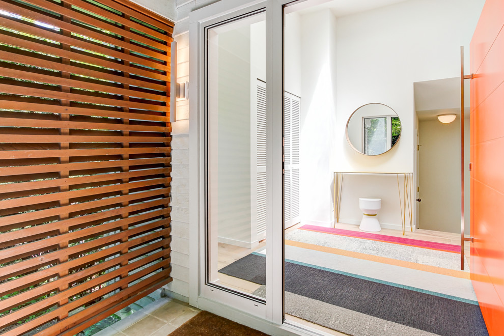 Idéer för en stor modern foajé, med vita väggar, ljust trägolv, en enkeldörr och en orange dörr
