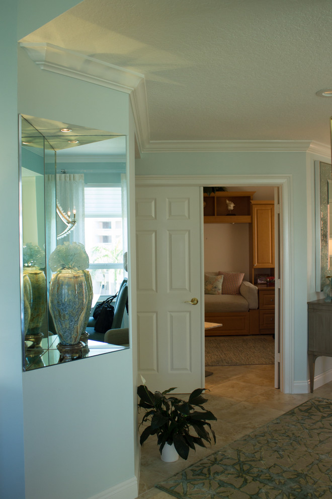 This is an example of a medium sized traditional foyer in Other with blue walls, ceramic flooring and beige floors.
