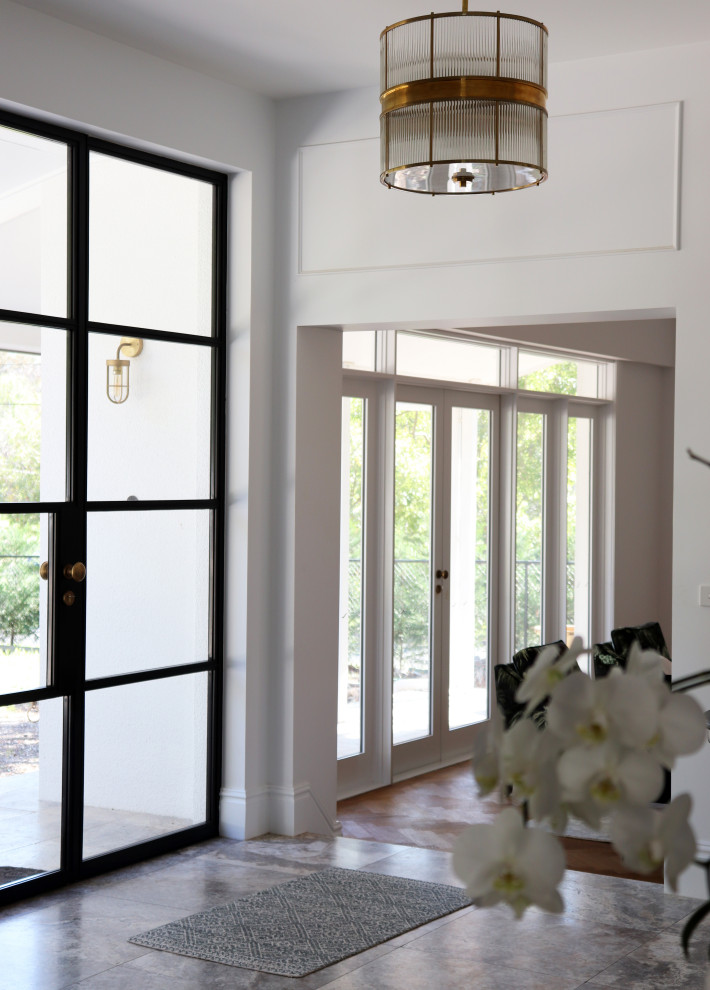 Foto di un grande ingresso classico con pareti bianche, parquet chiaro, una porta a due ante, una porta nera e pavimento marrone