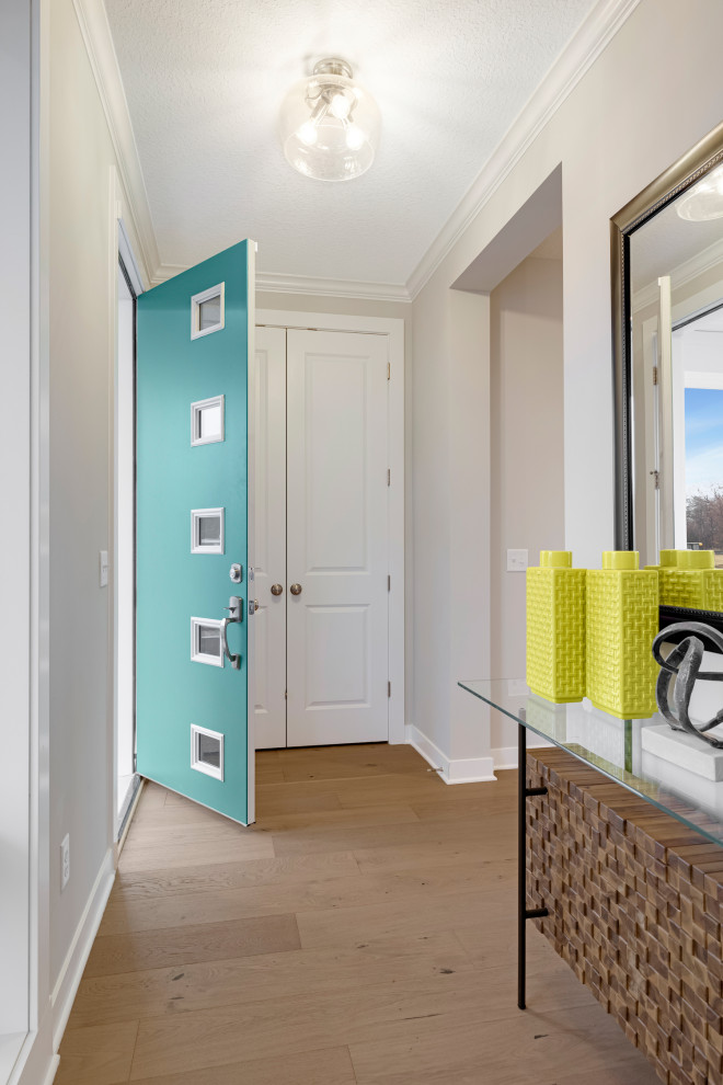 Idee per un ingresso classico con pareti bianche, parquet chiaro, una porta singola e una porta verde