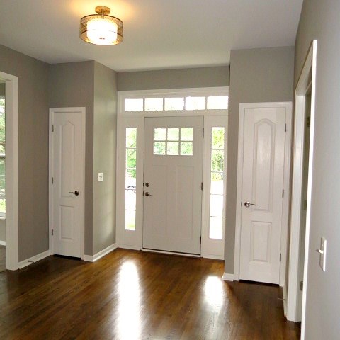 Traditional entrance in Cincinnati with grey walls, dark hardwood flooring, a single front door and a white front door.