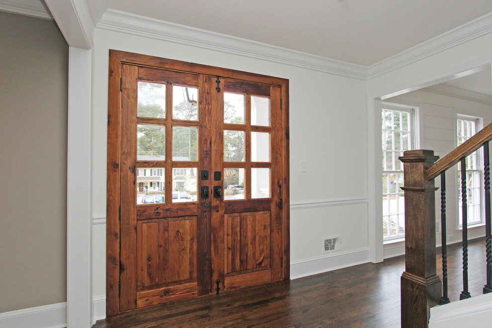 Example of a mid-sized eclectic dark wood floor entryway design in Atlanta with white walls and a medium wood front door