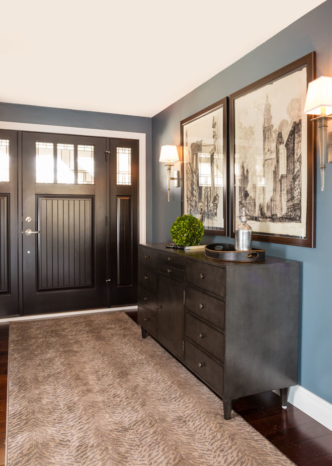Diseño de puerta principal tradicional de tamaño medio con paredes azules, suelo de madera en tonos medios, puerta de madera oscura, puerta simple y suelo marrón