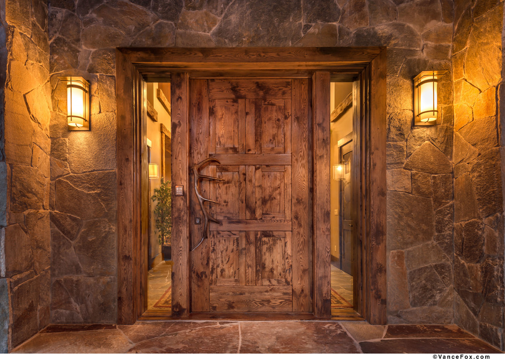 Источник вдохновения для домашнего уюта: большая входная дверь в стиле рустика с одностворчатой входной дверью и входной дверью из дерева среднего тона