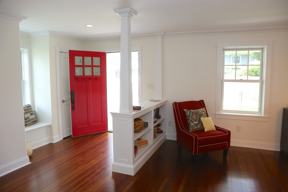 Bild på en liten amerikansk ingång och ytterdörr, med beige väggar, mellanmörkt trägolv, en enkeldörr, en röd dörr och brunt golv
