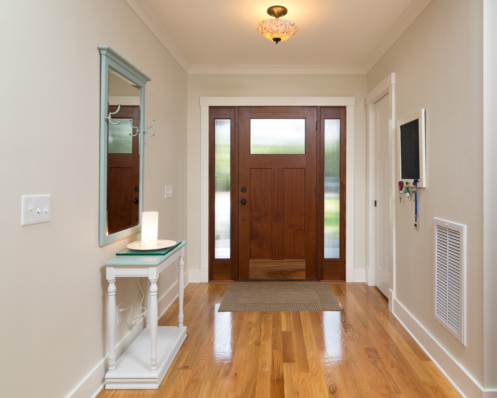 Idées déco pour une entrée craftsman de taille moyenne avec un couloir, un mur beige, parquet clair, une porte pivot et une porte en bois foncé.