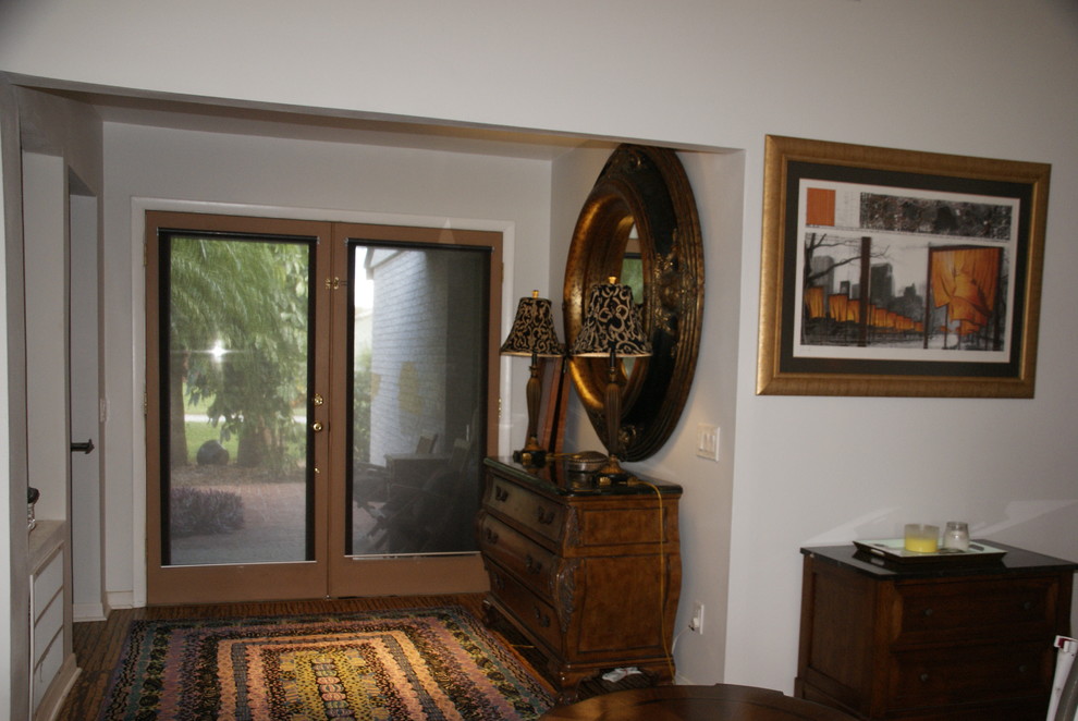 Cette image montre une petite entrée design avec un mur gris, un sol en liège, une porte double et une porte marron.