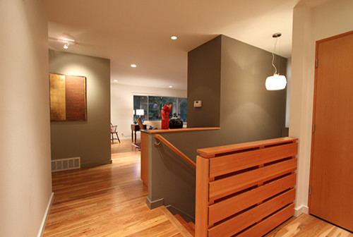 This is an example of a medium sized modern foyer in Seattle with grey walls, medium hardwood flooring, a single front door and a medium wood front door.